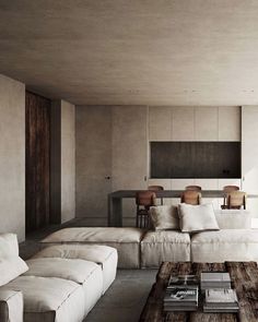 a living room filled with white couches next to a wooden coffee table and large windows