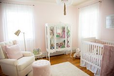 a baby's room with pink walls and white furniture