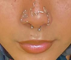 a woman with piercings on her nose and nose ring in front of her face