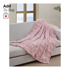 a pink blanket sitting on top of a couch