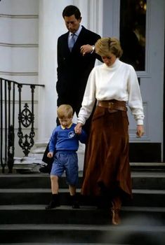 a man and woman are walking down the steps with a small boy in front of them