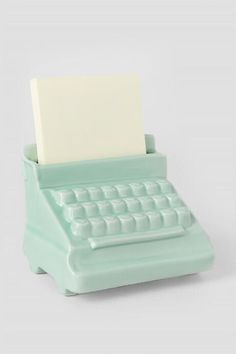 an old fashioned typewriter with a sticky pad attached to it