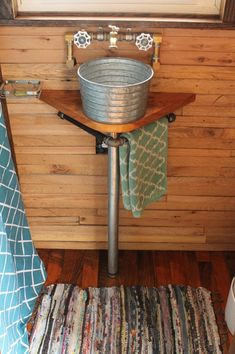 a bathroom with a sink and rugs on the floor in front of wooden walls