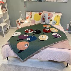 a bed with a colorful blanket on top of it in a room filled with furniture