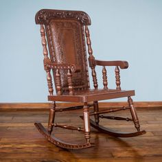 a wooden rocking chair with brown leather upholstered seat