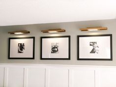 three framed photographs hang on the wall above a bench in front of white paneled walls