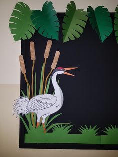 an image of a crane in the grass with palm leaves on it's back