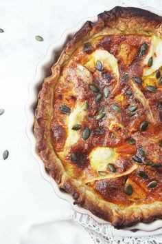 a quiche with bananas and other toppings in a pie dish on a lace doily