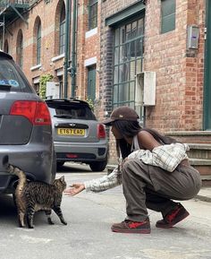 a woman petting a cat in front of a car