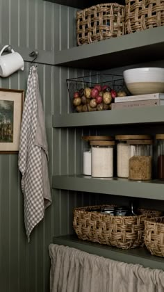 the shelves in this kitchen are organized with baskets and other things to put on them