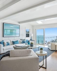 a living room filled with furniture and a large glass door leading to an ocean view