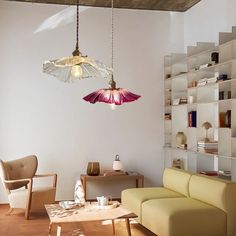 a living room filled with furniture and a lamp hanging from the ceiling