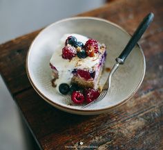 a piece of cake with berries on top in a bowl