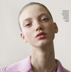 a young woman wearing a pink sweater and necklace