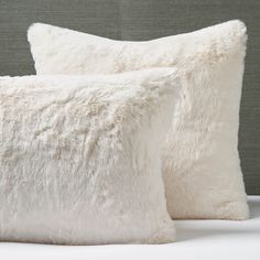 two white pillows sitting on top of a bed