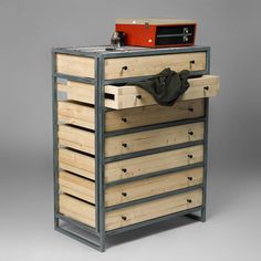 a wooden chest with drawers and a red box on top that is attached to it