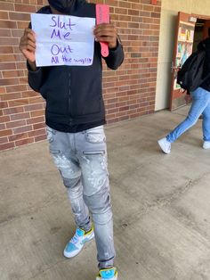 a young man holding up a sign that says shut me out all the time ago