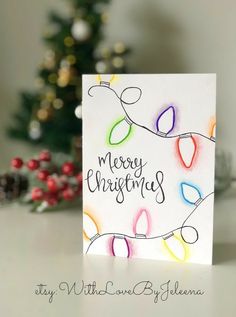 a christmas card with colorful lights on it