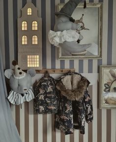 a baby's room with striped wallpaper and stuffed animals on the shelf next to it