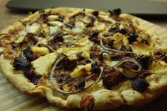 a pizza sitting on top of a wooden cutting board