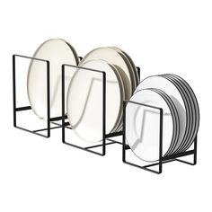 a stack of white plates sitting next to each other on a metal rack with black handles