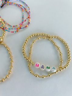 Mama or Mom beaded bracelet 14k gold filled stretch bracelet. Gold filled beads are water/tarnish resistant. So great for stacking! Colorful letters have been clear coated to provide water protection. Please note they will probably not out last gold filled beads. Colors of the letters will vary Choose length Choose mom or mama Materials made in the USA then assembled in our MS studio. **Sizing note: If you need to look up what you've previously purchased just email us. Measure your wrist at home Beads Colors, Creating Jewelry, Clear Coat, Pure Gold, Bracelet Gold, Gold Filled Jewelry, Gold Plated Jewelry, Jewelry Plate, Stretch Bracelet