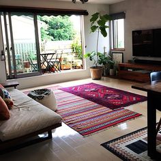 a living room filled with furniture and a flat screen tv on top of a wooden table