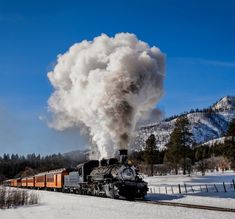 an old fashioned steam train traveling through the snow