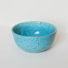 a blue speckled bowl on a white surface