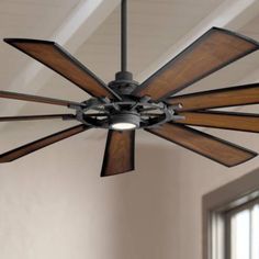 a ceiling fan with wooden blades in a room