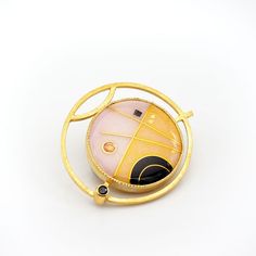 This modern convertible brooch pendant has a 24K gold cloisonne vitreous enamel on silver jewel in a geometric design with deep black, petal pink and warm yellow set into gold vermeil over sterling silver with faceted black spinel, enamel measures 1" diameter, overall 1.5" Luxury Gold Enamel Brooch, Luxury Gold Enamel Brooches, Modern Enamel Jewelry With Gemstone, Yellow Gold Enamel Brooch Jewelry, Unique Yellow Gold Enamel Brooch, Gold Brooch With Large Pendant As Gift, Yellow Gold Enamel Brooches For Gifts, Luxury Gold Enamel Pin As Gift, Luxury Gold Enamel Pin For Gift