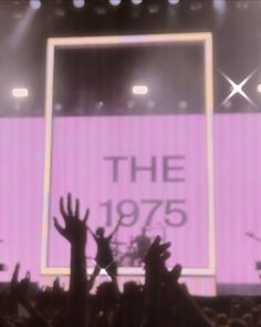 people are raising their hands in front of a large screen with the words the 1970 on it