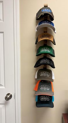 a wall mounted hat rack with six hats hanging on it's sides and the door open