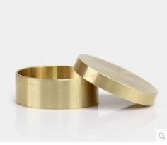 two gold wedding rings sitting next to each other