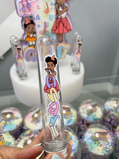 a person holding up a glass tube with an image of a cartoon character on it