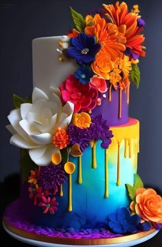 a multicolored cake with flowers and dripping icing