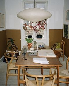 a dining room table with several chairs around it and a lamp hanging from the ceiling