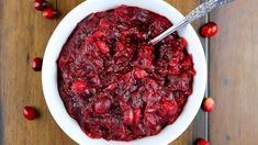 a white bowl filled with cranberry sauce on top of a wooden table