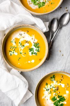 two bowls filled with soup and garnished with parsley