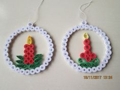 two christmas ornaments made out of plastic beads and string, each with a candle in the center