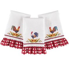 two kitchen towels with roosters and sunflowers on them, one is red and the other is white