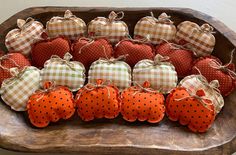 a wooden tray filled with pumpkins and polka dotty bags on top of each other