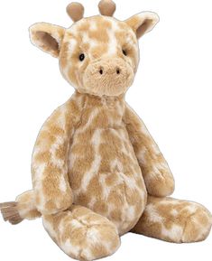 a stuffed giraffe sitting on the ground with it's head turned to the side