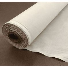 a roll of white fabric sitting on top of a floor