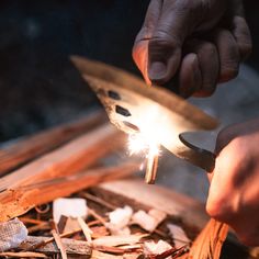 a person holding a lighter in their hand while working on some woodworking projects with other hands