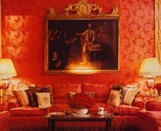 a living room filled with red couches next to lamps and paintings on the wall