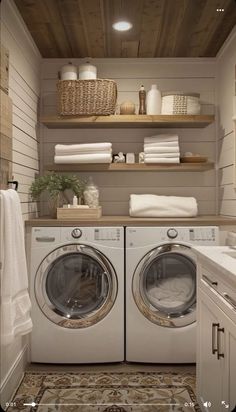 a washer and dryer in a small room with shelves above the washer