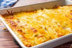 a casserole dish with cheese and meat in it on a wooden table top