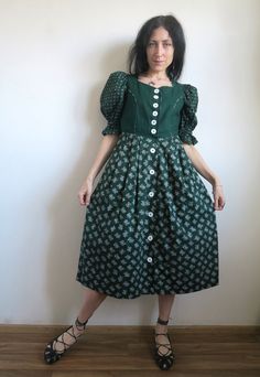 "Vintage Austrian folk dress by Distler Original. Traditional princess style with fitted bodice, puffed short sleeves (elastic in the bottom shaping a ruffle) and full pleated skirt. The bodice is green linen-cotton blend.  Features sweetheart neckline and pointed waist. The sleeves and the skirt made with 2 different but matching printed cotton fabrics. White cotton lining on the bodice. Massive white buttons down the front. There are side slits in the skirt. The dress got side pockets! Also got sleeve puffers. This is a super-lovely dress in a rare-for-dirndls size XS. Please check the measurements: armpit  ~ 86 cm  /  ~  33 \"  waist ~ 68 cm  /  ~ 26 \"  length  ~ 114 cm  /  ~  44.5 \"  In great vintage condition." Fitted Patchwork Puff Sleeve Dresses, Fitted Peasant Dress With Smocked Bodice And Puff Sleeves, Vintage Full Skirt Costume Dress, Fitted Peasant Dress With Puff Sleeves For Daywear, Fitted Peasant Prairie Dress, Peasant Style Square Neck Fitted Dress, Vintage Green Puff Sleeve Dress, Green Puff Sleeve Dress In Cottagecore Style, Fitted A-line Vintage Prairie Dress