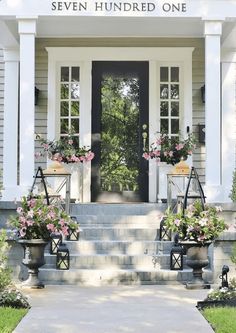 the front entrance to seven hundred one with potted flowers on each step and an entry way leading up to it